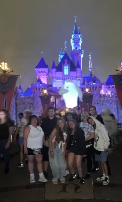 Group of friends in front of Sleeping Beauty Castle at night