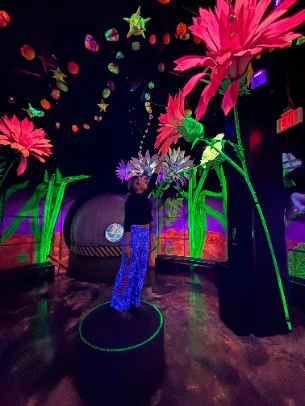Cailin posing in a glowing blacklight art exhibit
