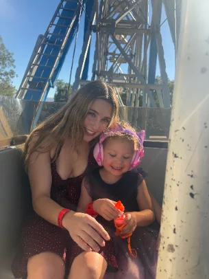 Cailin and a young girl riding a roller coaster